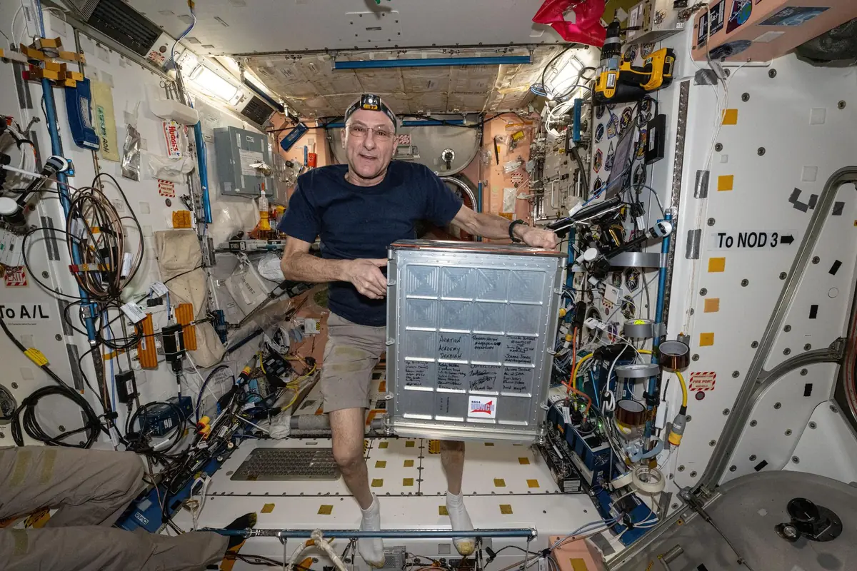 Astronaut Don Pettit showing student-made HUNCH gear inside the International Space Station